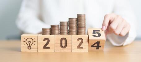 2024 end year to Happy New Year 2025 with Coins stack and lightbulb icon. Business Idea, Creative, Thinking, brainstorm,Money, Budget, investment, financial, savings and New Year Resolution concept photo