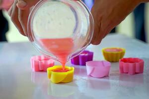 Students like to make handmade soap by pouring the soap ingredients into silicone molds in the shapes they want. soft and selective focus. photo