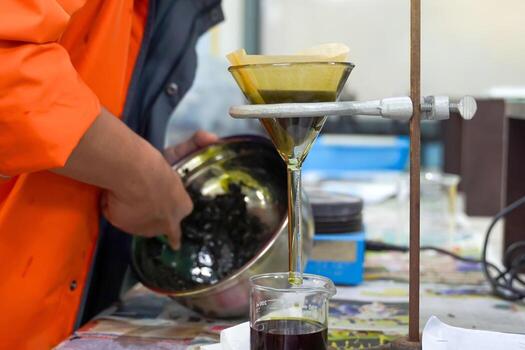 Experiment to separate mixed substances by pouring substances into a separator funnel through filter paper. Solid particles are placed on the filter paper. The liquid will flow into the beaker below. photo