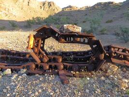 Abandoned Old Machine Treads with Rock on Top Rusting in Arizona Desert photo