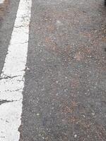 Perspective view of asphalt road texture with white markings on the left side. Copy space concept. asphalt texture and straight road lines photo
