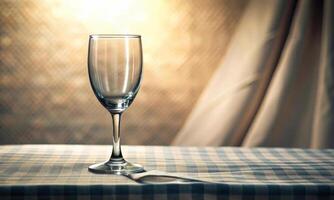 A glass on a light table, on an illuminated background with a curtain photo