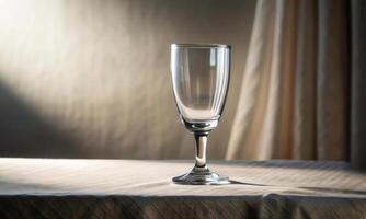 A glass on a light table, against the background of a curtain photo