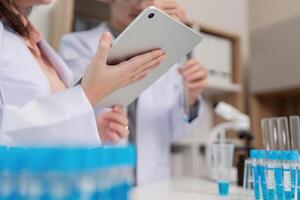 Research Scientist Using Tablet for Data Collection in Chemistry Lab photo