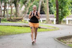 Active Elderly Woman Embracing Joyful Walking Routine in a Natural Park Setting photo