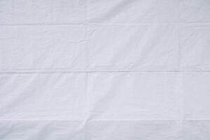 White tarpaulin with folds and creases as background texture photo