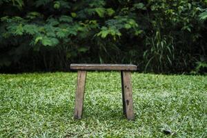 a small wooden stool sitting on the grass photo