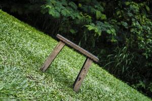 a wooden bench sitting on the grass in the middle of a field photo