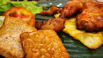 a plate with fried chicken, bread and vegetables photo