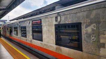a train is parked at a station with people standing around photo
