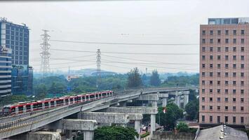 a train traveling on a bridge over a city photo