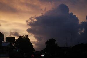 a cloudy sky with a sign in the foreground photo