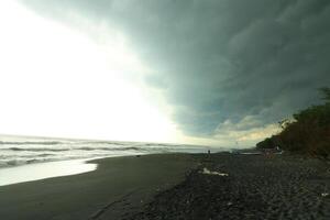 a person on a beach with a boat and a storm photo