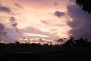 a cloudy sky with a sign in the foreground photo