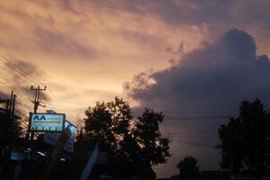 a cloudy sky with a sign in the foreground photo