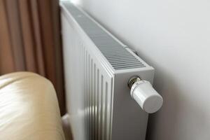 modern radiator for heating in the apartment with power regulators. ideal for those costs of heating and utilities in winter, warmth and comfort in the apartment photo