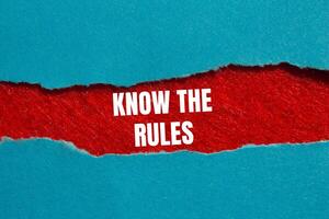 Know the rules message written on ripped torn blue paper on red background. Conceptual know the rules symbol. Copy space. photo