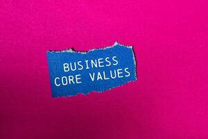 Business core values message written on ripped blue torn paper piece on pink background. Conceptual business core values symbol. Copy space. photo