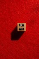 New way message written on wooden cube with red background. Conceptual new way symbol. Copy space. photo