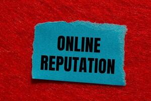 Online reputation message written on ripped torn blue paper piece with red background. Conceptual online reputation symbol. Copy space. photo