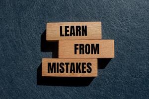 Learn from mistakes message written on wooden blocks with gray background. Conceptual learn from mistakes symbol. Copy space. photo