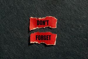 Don't forget message written on ripped torn red paper pieces with gray background. Conceptual don't forget symbol. Copy space. photo