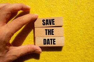 Save the date message written on wooden blocks with yellow background. Conceptual save the date symbol. photo