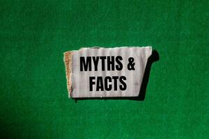 Myths and facts message written on ripped torn white paper piece with green background. Conceptual myths and facts symbol. Copy space. photo