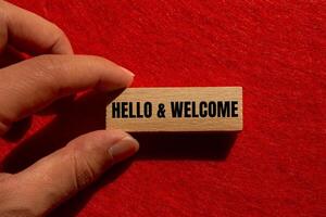Hello and welcome message written on wooden block with red background. Conceptual hello and welcome symbol. Copy space. photo