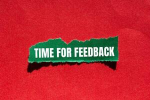 Time for feedback message written on ripped torn green paper piece with red background. Conceptual time for feedback symbol. Copy space. photo