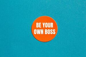 Be your own boss message written on round orange sticker with blue background. Conceptual be your own boss symbol. Copy space. photo