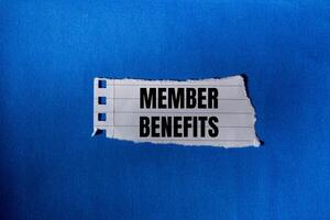 Member benefits message written on ripped torn paper piece with blue background. Conceptual member benefits symbol. Copy space. photo