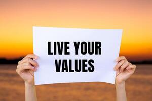 Live your values message written on white paper with blurry lake background. Conceptual live your values symbol. Copy space. photo