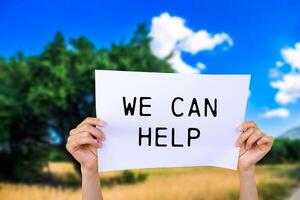 We can help message written on white paper with nature background. Conceptual we can help symbol. Copy space. photo