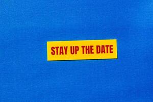 Stay up the date message written on yellow sticker with blue background. Conceptual stay up the date symbol. Copy space. photo