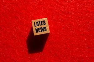 Latest news message written on wooden cube with red background. Conceptual latest news symbol. Copy space. photo