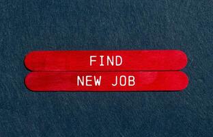Find new job message written on red wooden sticks on gray felt background. Conceptual find new job symbol. Copy space. photo
