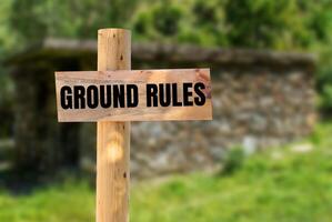 Ground rules message written on wooden sign with nature background. Conceptual ground rules symbol. Copy space. photo