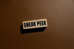 Sneak peek message written on wooden block with brown background. Conceptual sneak peek symbol. Copy space. photo