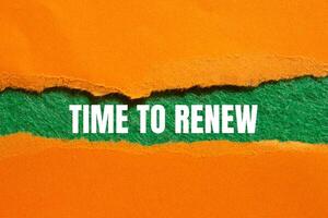 Time to renew message written on ripped torn orange paper with green background. Conceptual time to renew symbol. Copy space. photo