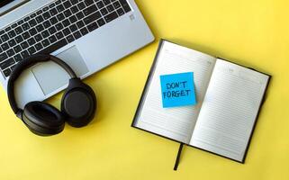 sticker reminder don't forget in notebook, laptop and notebook on beautiful green background photo