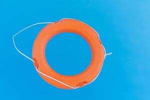 bright orange lifebuoy floating on the surface of the water, rescuing people on the water photo