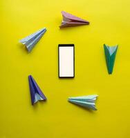 paper airplanes chaotically circle around the phone. abstraction on the theme of messages and communication photo
