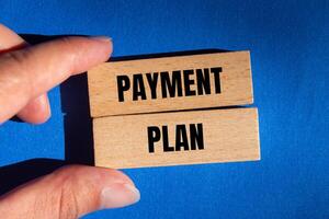 Payment plan message written on wooden blocks with blue background. Conceptual payment plan symbol. Copy space. photo