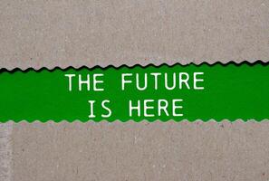 The future is here message written on ripped torn paper on green background. Conceptual the future is here symbol. Copy space. photo