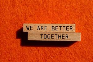We are better together message written on wooden blocks on orange felt background. Conceptual we are better together symbol. Copy space. photo