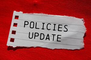 Policies update message written on ripped torn paper piece with red background. Conceptual policies update symbol. Copy space. photo