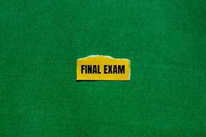 Final exam message written on ripped torn yellow paper piece with green background. Conceptual final exam symbol. Copy space. photo
