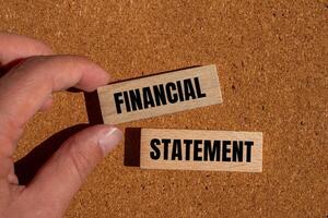 Financial statement message written on wooden blocks with brown background. Conceptual financial statement symbol. Copy space. photo