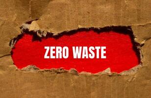 Zero waste message written on torn cardboard paper with red background. Conceptual zero waste symbol. Copy space. photo